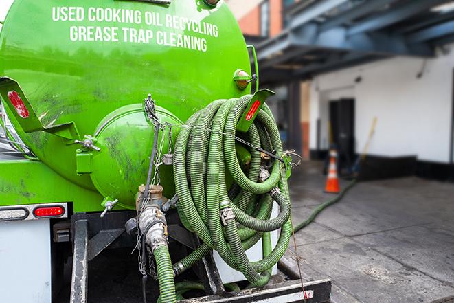 maintenance crew pumping grease trap at a fast food restaurant in Newtonville